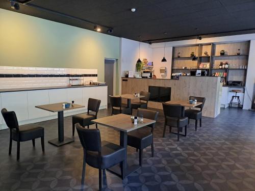 a restaurant with tables and chairs and a counter at B&B de Wilhelminaschool in Aalten