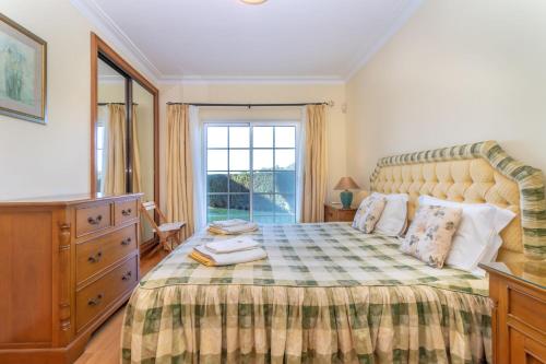 a bedroom with a large bed and a window at Casa Presa da Moura in Carvoeiro