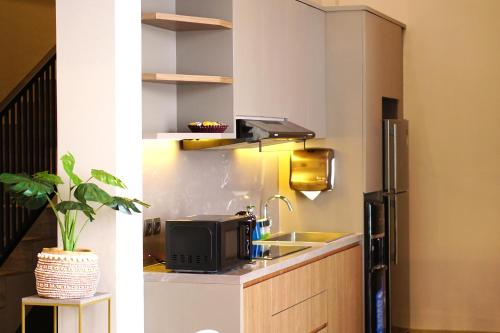 uma cozinha com um lavatório e um frigorífico em The Balcone Suites & Resort Powered by Archipelago em Bukittinggi