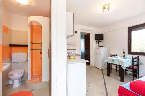 a bathroom with a toilet and a kitchen with a table at Apartment in Vrbnik/Island Krk 35842 in Vrbnik
