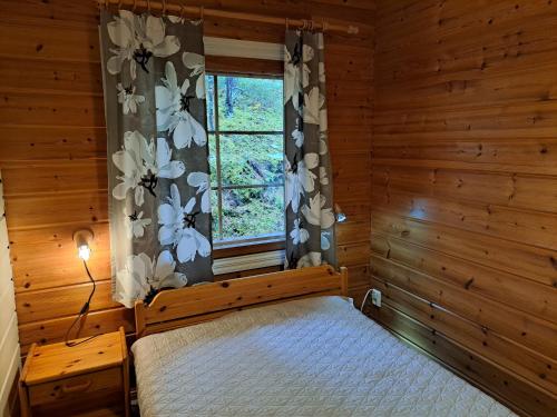 a bedroom with a bed and a window at Nelisyöte A in Syöte