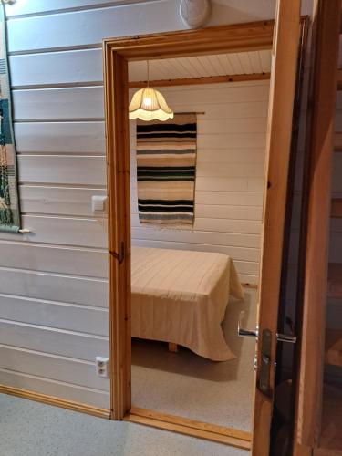 a door leading into a small room with a bed at Nelisyöte A in Syöte