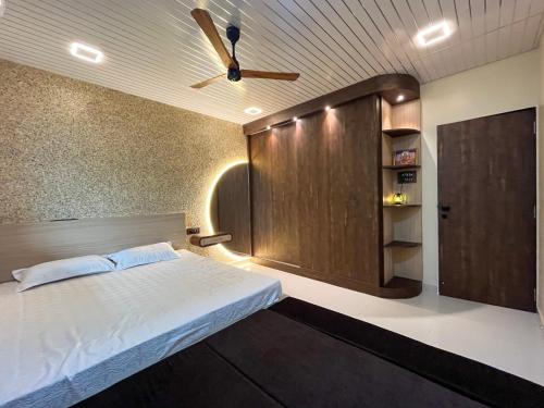 1 dormitorio con 1 cama y puerta de madera en Cloud9 Villa (Yeoor Hills, Thane) - A Luxurious Private Jungle Villa., en Thane