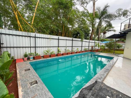 a swimming pool in a backyard with a fence at Cloud9 Villa (Yeoor Hills, Thane) - A Luxurious Private Jungle Villa. in Thane