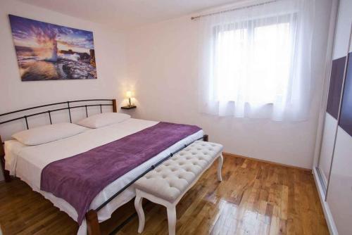 um quarto com uma cama grande e uma janela em Apartment in Vrbnik - Insel Krk 36848 em Vrbnik