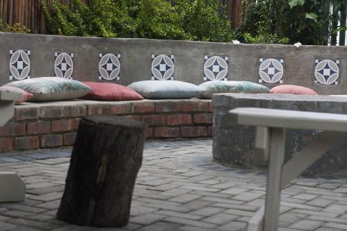 a row of pillows sitting on a brick bench at De Akker Guest House Oudtshoorn in Oudtshoorn