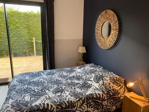 Schlafzimmer mit einem Bett und einem Wandspiegel in der Unterkunft Charmant studio entre bassin et océan in Lège-Cap-Ferret