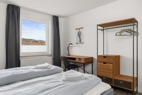 1 Schlafzimmer mit 2 Betten, einem Schreibtisch und einem Fenster in der Unterkunft CASSEL LOFTS - Komfortable Wohnung für 4 mit Balkon nahe VW-Werk in Kassel