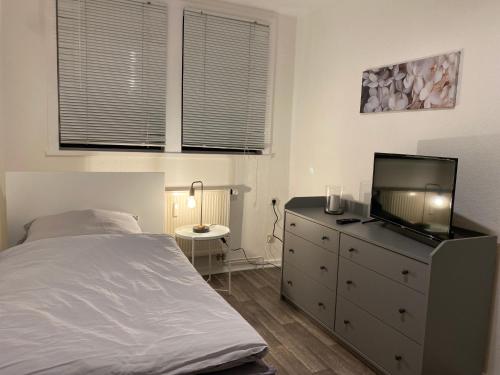 a bedroom with a bed and a tv on a dresser at Balance Apartments by M&A - Train station in Witzenhausen