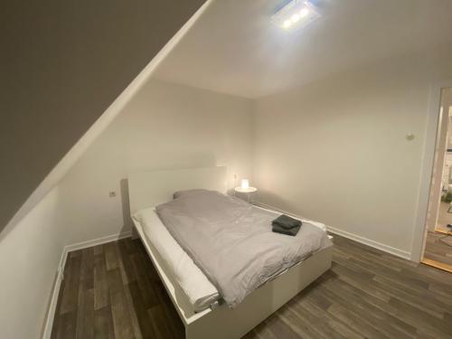 a white bedroom with a bed with a lamp on it at Balance Apartments by M&A - Train station in Witzenhausen