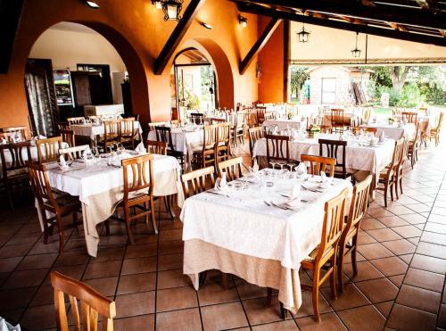 jadalnia z białymi stołami i krzesłami w obiekcie Agriturismo Podere Giulio w mieście Tarquinia