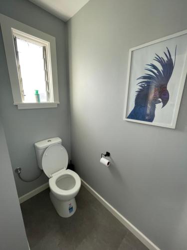 a bathroom with a toilet and a picture on the wall at Minimalist Cabin Solo Traveller in Ashburton