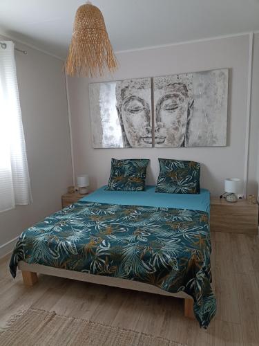 Schlafzimmer mit einem Bett mit blauer Decke in der Unterkunft Ti Kaz Nayagom in Saint-Pierre