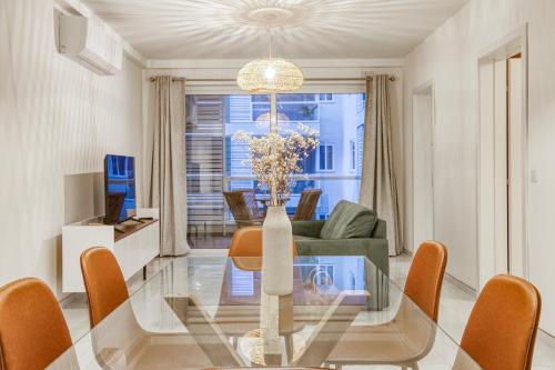 uma sala de jantar e sala de estar com uma mesa de vidro em A beautiful, brand new 2BR home in St Pauls by 360 Estates em St. Paul's Bay