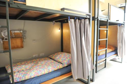 a room with two bunk beds in a room at Taitung Ohana Sky Hostel in Taitung City