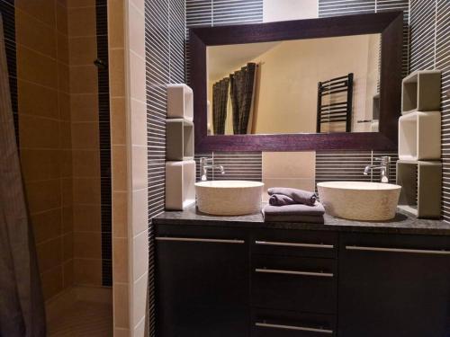 a bathroom with two sinks and a mirror at Villa de 2 à 10 personnes tarif en fonction du nombre de personnes in Vonnas