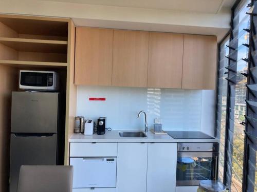kuchnia ze zlewem i lodówką w obiekcie Stylish , CBD , Views w Melbourne