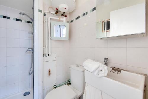 une salle de bain blanche avec des toilettes et un lavabo dans l'établissement La Suite 24 - Studio avec Terrasse à 100m du port de Saint-Martin-de-Ré, à Saint-Martin-de-Ré