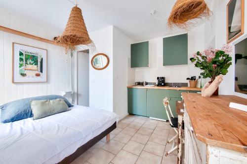 une chambre avec un lit et une cuisine dans l'établissement La Suite 24 - Studio avec Terrasse à 100m du port de Saint-Martin-de-Ré, à Saint-Martin-de-Ré