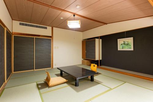 a living room with a table and a chair at Ooedo Onsen Monogatari Higashiyama Grand Hotel in Aizuwakamatsu