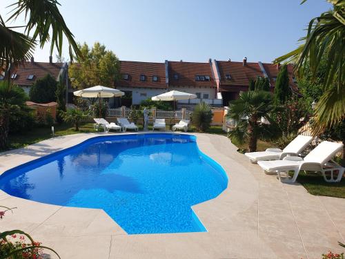 una piscina con tumbonas y sombrillas en Paradise-Garden-Zamardi, en Zamárdi