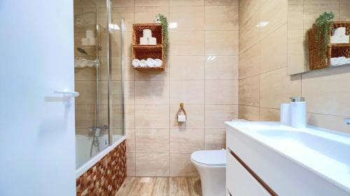 Un baño con bañera, inodoro y lavabo. en La Torre - terraza y vistas al mar, en Torre de la Horadada