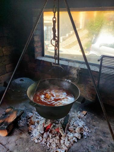 a pot of food is cooking on a grill at Vila MP Banstol 4*- Brdež do, Fruška gora in Inđija