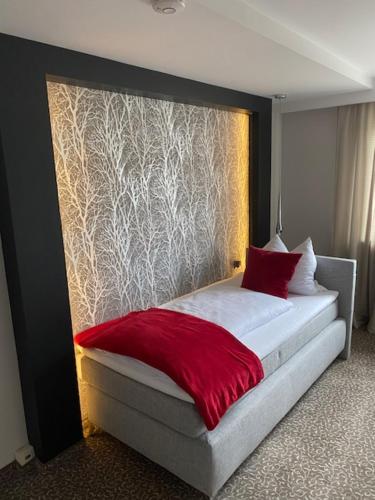 1 dormitorio con 1 cama con manta roja en Ahorn-Zimmervermietung, en Schrobenhausen