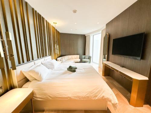 ドバイにあるLuxury Stay At Five Palm Residenceのベッド2台と薄型テレビ付きのベッドルーム