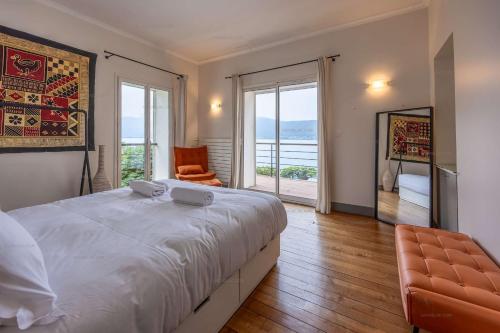 a bedroom with a large white bed and a chair at Villa 83 Veyrier - Veyrier du lac in Veyrier-du-Lac