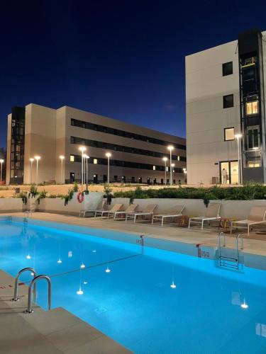 a swimming pool in front of a building at night at NODIS MADRID POZUELO in Madrid