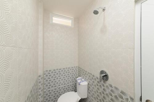 a bathroom with a toilet and a shower at RedDoorz near GSG UNILA Lampung in Hajimana