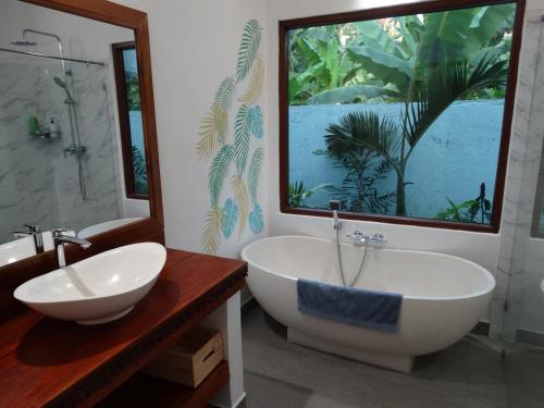 a bathroom with a large window and a tub and sink at Villa Serenity in Candidasa
