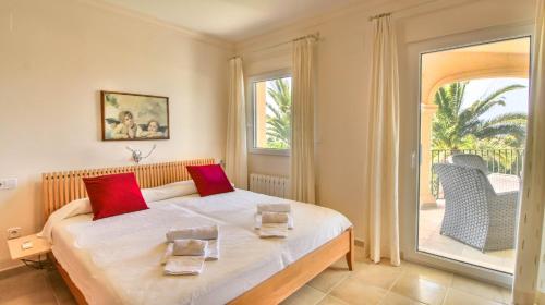 een slaapkamer met een bed met rode kussens erop bij Belem GS in Denia