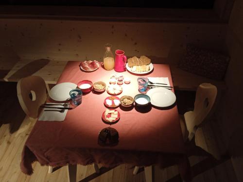 einem roten Tisch mit Essen darüber in der Unterkunft Maso Torbiera- Rural and Mountain lodging in Fiavè
