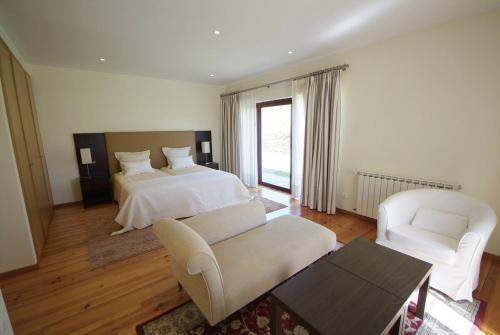 ein großes Schlafzimmer mit einem Bett und zwei Stühlen in der Unterkunft Villa 241 in Ponte de Lima