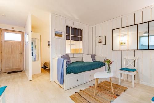 een slaapkamer met een bed en een tafel. bij Le Relax - Appt avec terrasse à 5mn de la plage in Arcachon