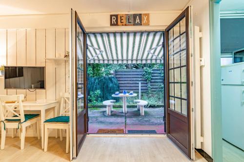 une porte coulissante en verre menant à une terrasse avec une table. dans l'établissement Le Relax - Appt avec terrasse à 5mn de la plage, à Arcachon