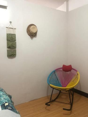 einen farbenfrohen Stuhl in einem Zimmer mit einer Wand in der Unterkunft Amenadiel & CC - Imus Staycation in Imus