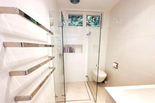 a bathroom with a glass shower and a toilet at Charming 3 Bedroom Artist House in Mosman in Sydney