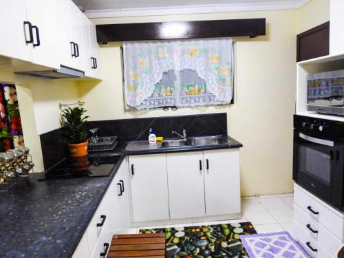 a kitchen with a sink and a microwave at Yaubula Accommodation 2 in Nadi