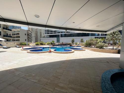 a building with several swimming pools in a courtyard at Casa Vera Vacations in Dubai