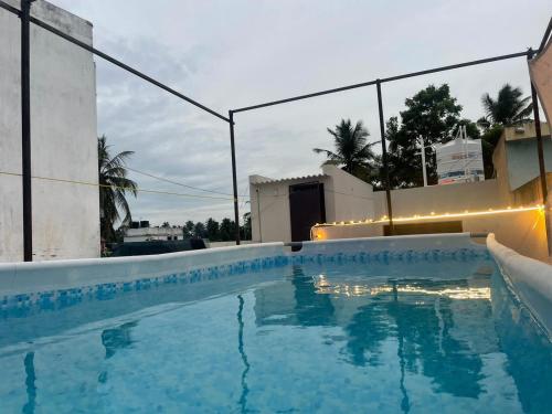 een groot zwembad met verlichting aan de zijkant van een gebouw bij Villa Porto' Lux beach house', Pondicherry in Pondicherry