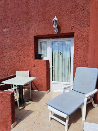 a patio with a table and a chair and a window at Appartements Luccisano in Borgo