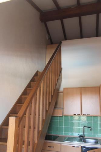 une cuisine avec un évier et un escalier en bois dans l'établissement Trilocale in residence con piscina a 200 m dal mare, à Linguizzetta