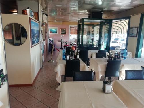 une salle à manger avec des tables et des chaises blanches dans l'établissement HOTEL GIORDANA, à Loano