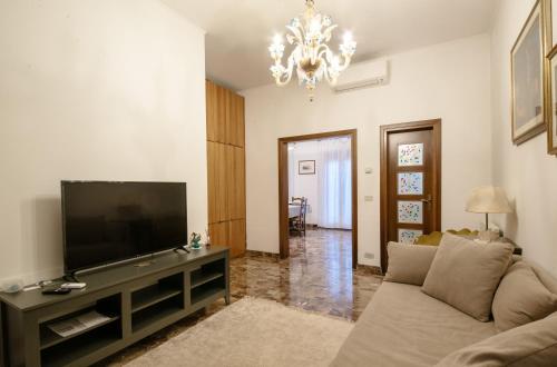 uma sala de estar com um sofá e uma televisão de ecrã plano em Central Apartment Ca' dei Ferro - MURANO Venice em Murano