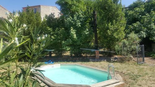 - une piscine avec une chaise dans la cour dans l'établissement Gîte de charme la belle histoire, à Prades