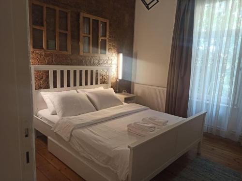 un letto bianco in una camera da letto con finestra di Merkezi Konforlu ve Şık Daire a Istanbul