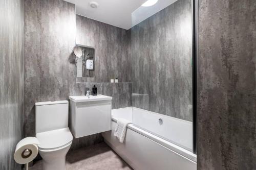 La salle de bains est pourvue de toilettes blanches et d'une baignoire. dans l'établissement Panoramic Sea View 2 bedroom Sleeps 6-Free Parking, à Bournemouth